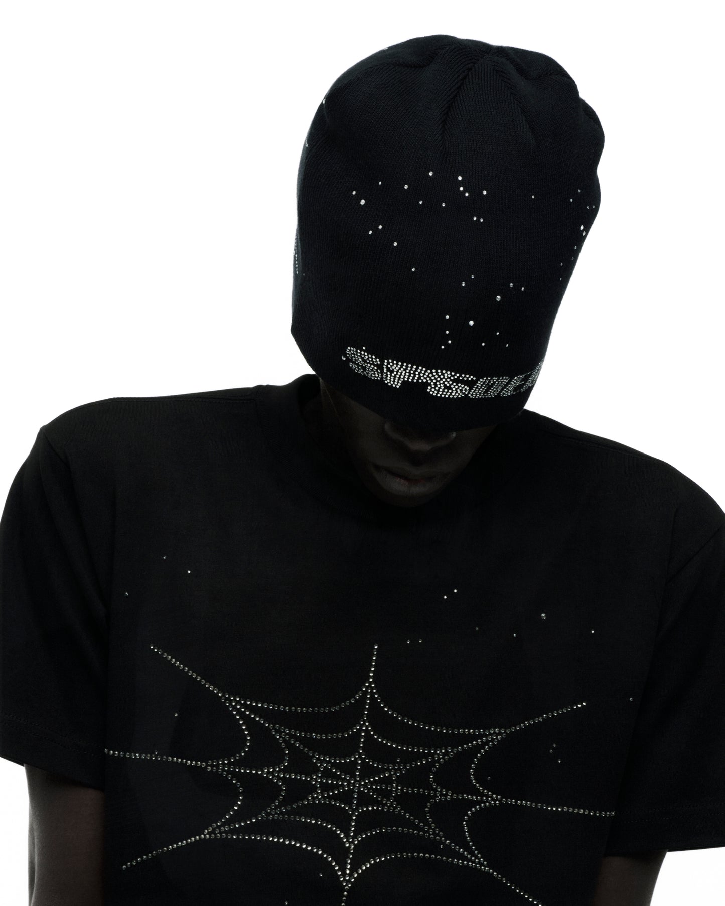 Black acrylic beanie with rhinestone skull design, paired with a black tee featuring a rhinestone spiderweb.