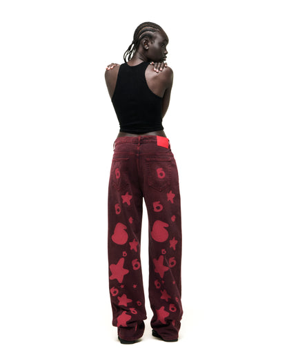 Faded wash Beluga Denim pants with red graphic print, branded hardware, and leather back patch.