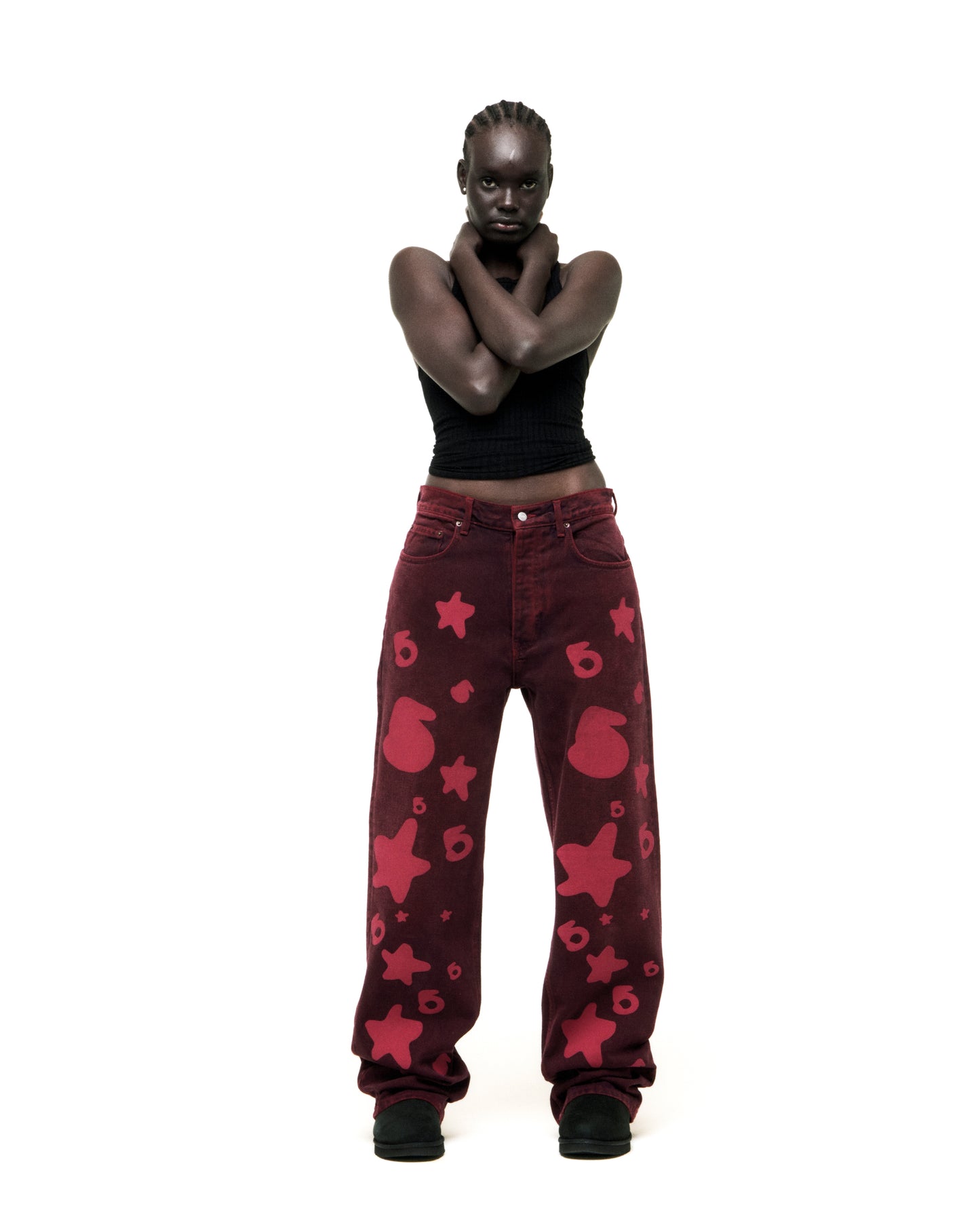 Model wearing faded wash Beluga print red denim pants with custom hardware and classic straight leg fit.