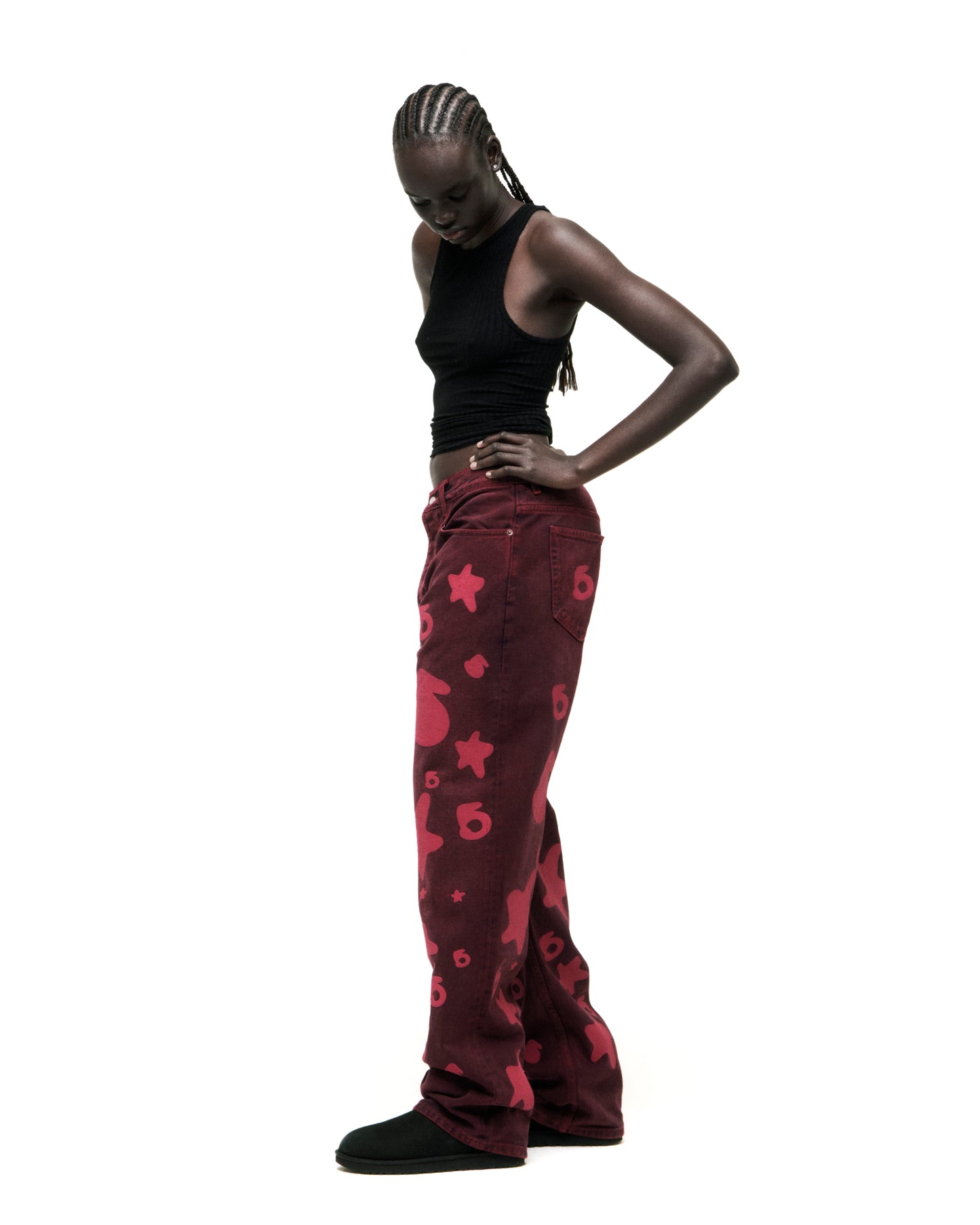 Model in faded wash Beluga Denim jeans with red print design, custom hardware, and leather back patch.