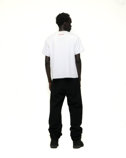 Model from behind wearing a white Vivienne Tee with red 'SP5DER' logo on back neck and black pants.
