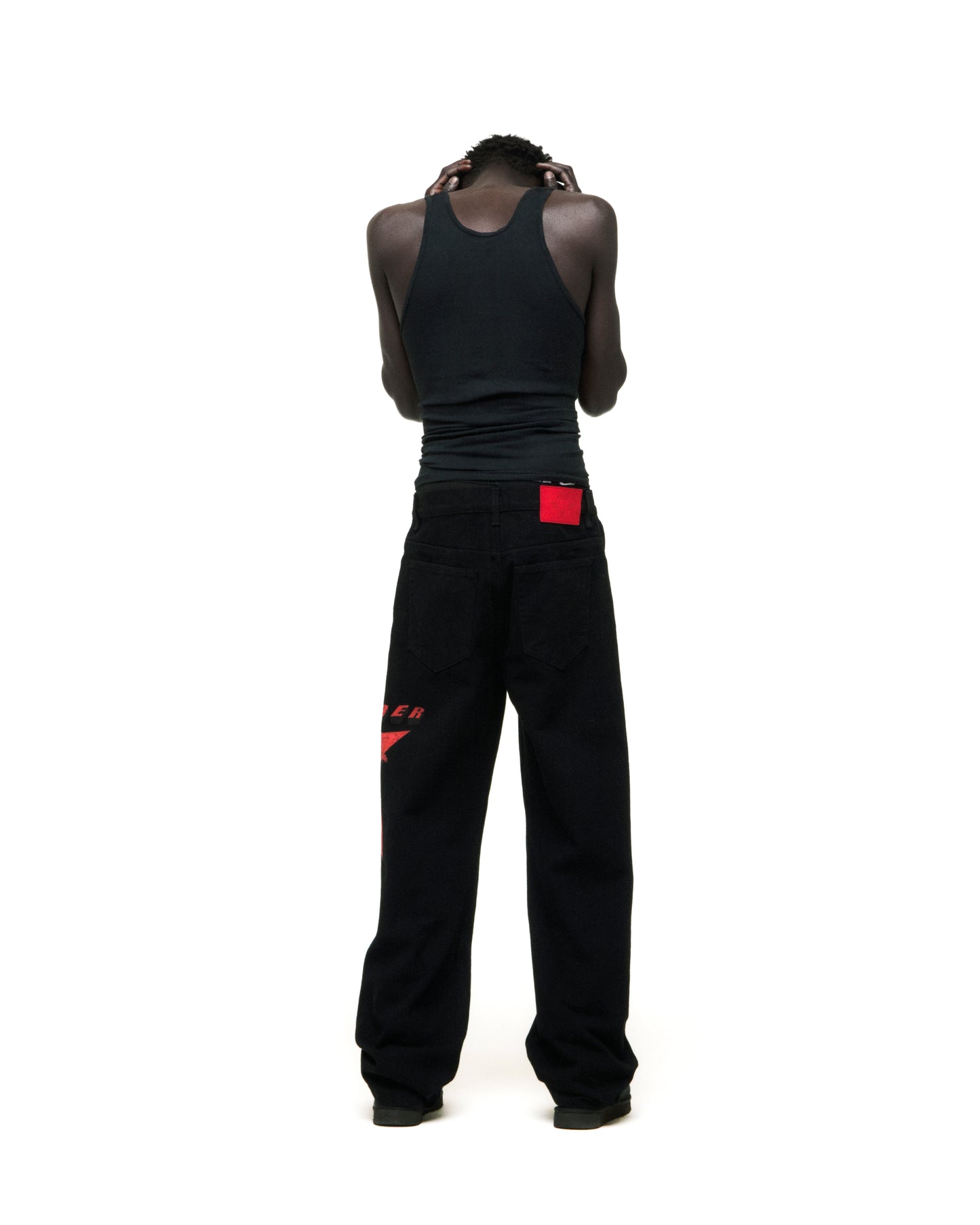 Black denim pants with red star graphic on upper leg and red branded back patch.