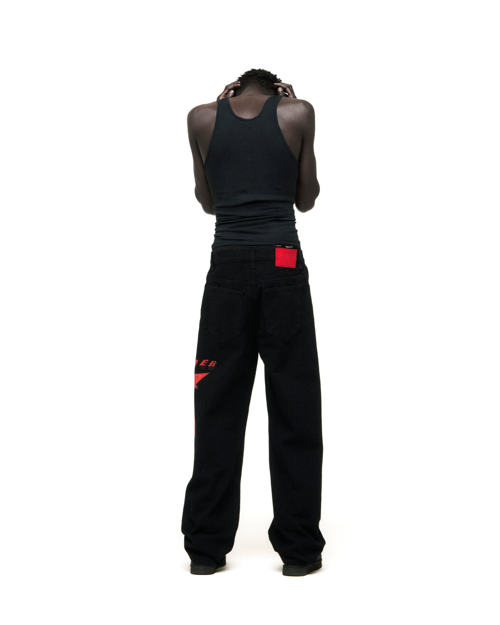 Black denim pants with red star graphic on upper leg and red branded back patch.