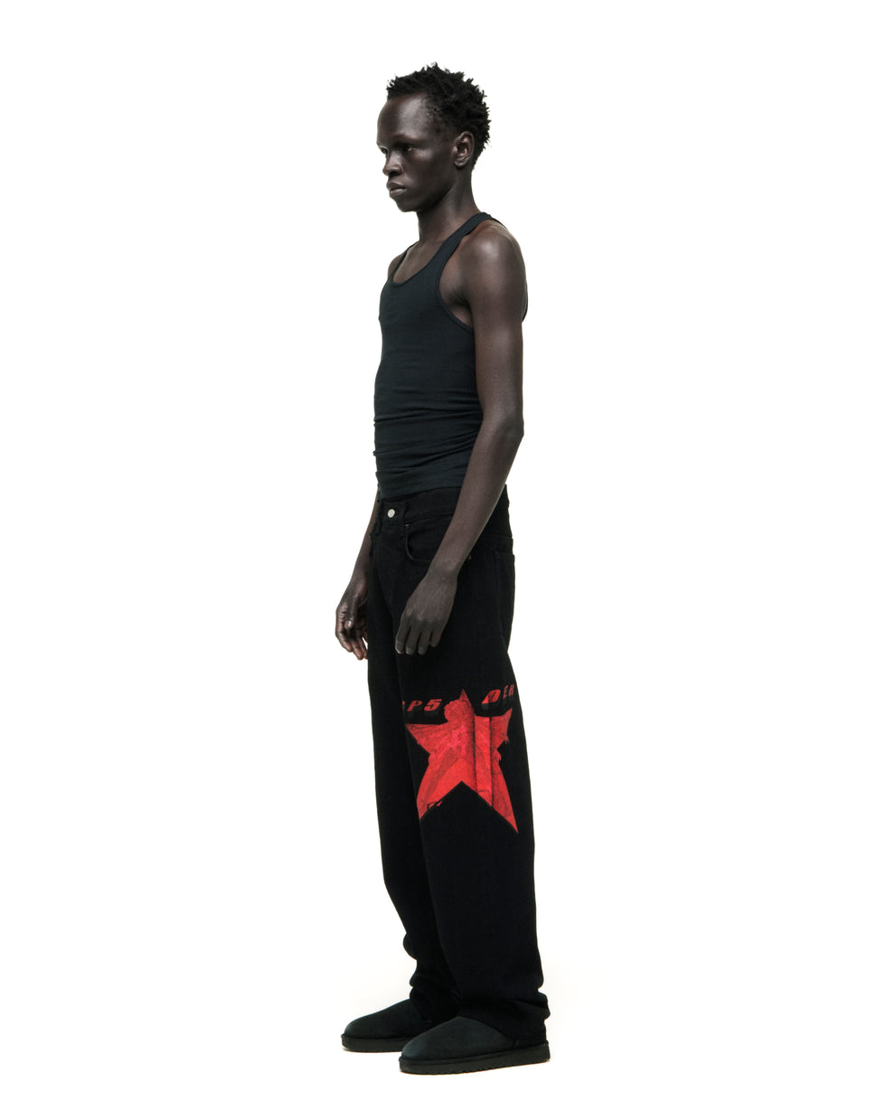 Black STAR GIRL DENIM jeans with a large red star graphic on the upper leg, worn by a man in a black tank top.