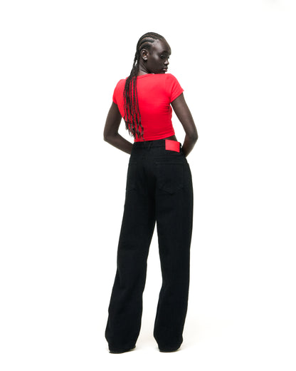 Model in black denim pants with a red back patch and a red crop top.