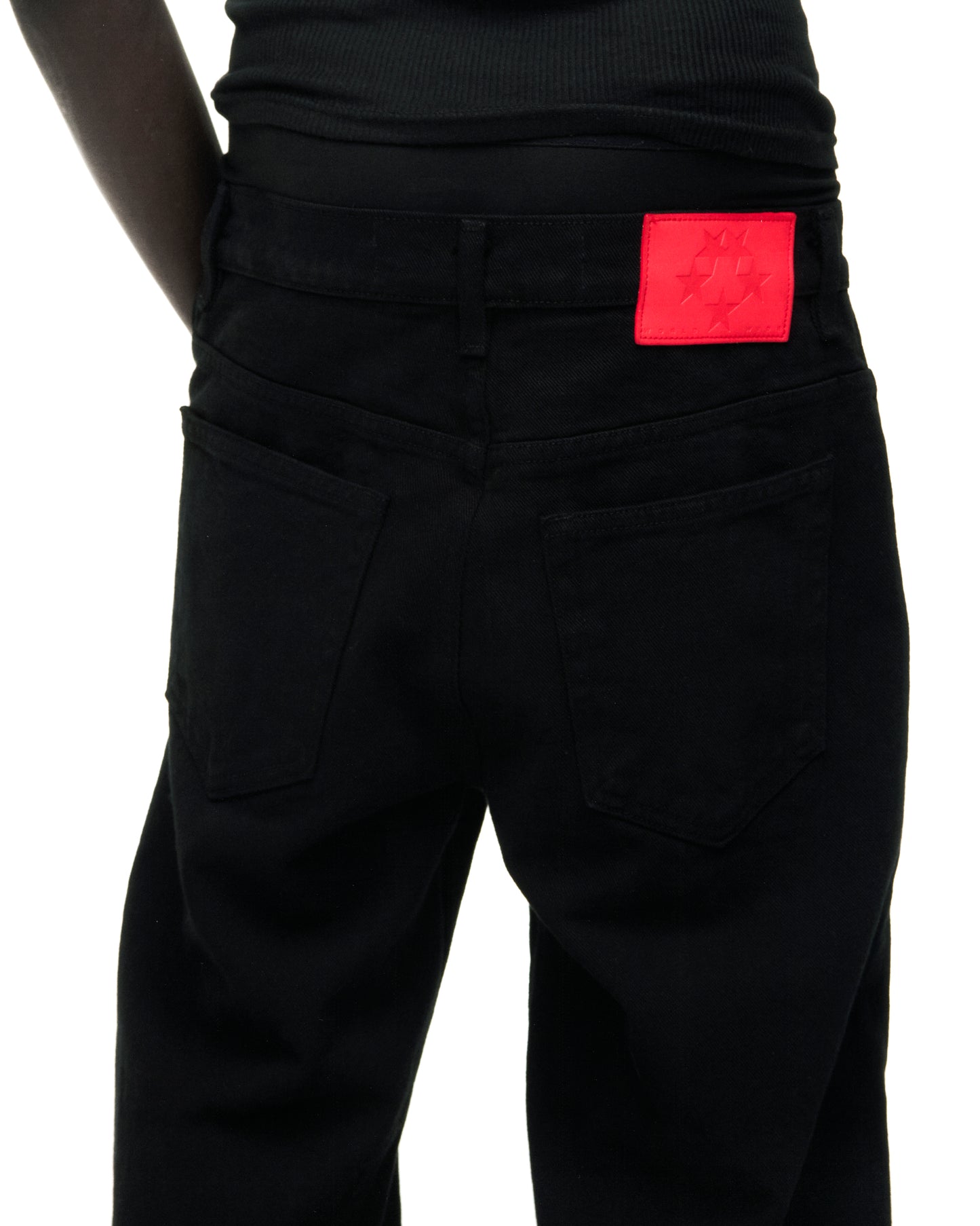 Black V3 DENIM jeans with a red branded leather back patch and five-pocket styling.