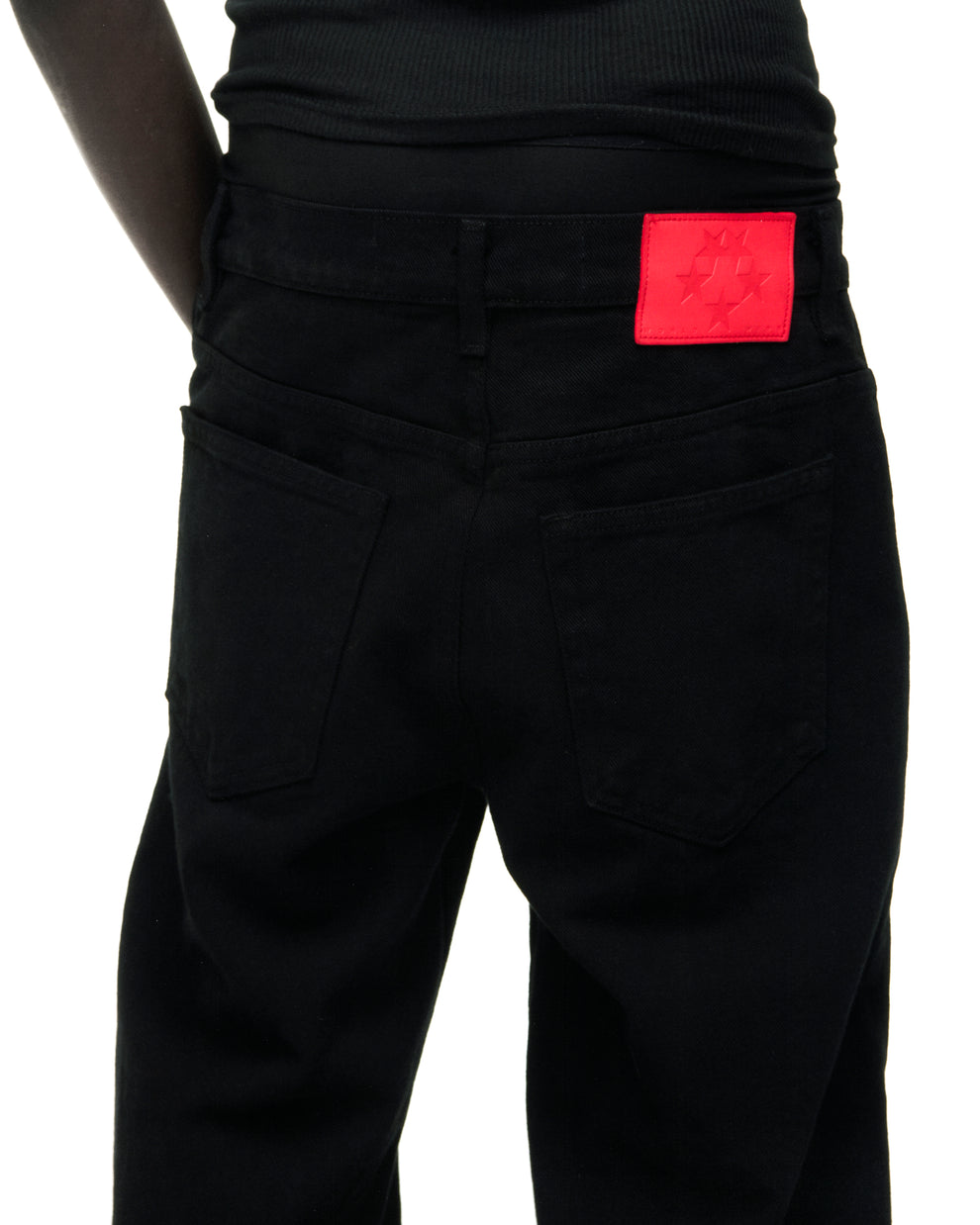 Black V3 DENIM jeans with a red branded leather back patch and five-pocket styling.
