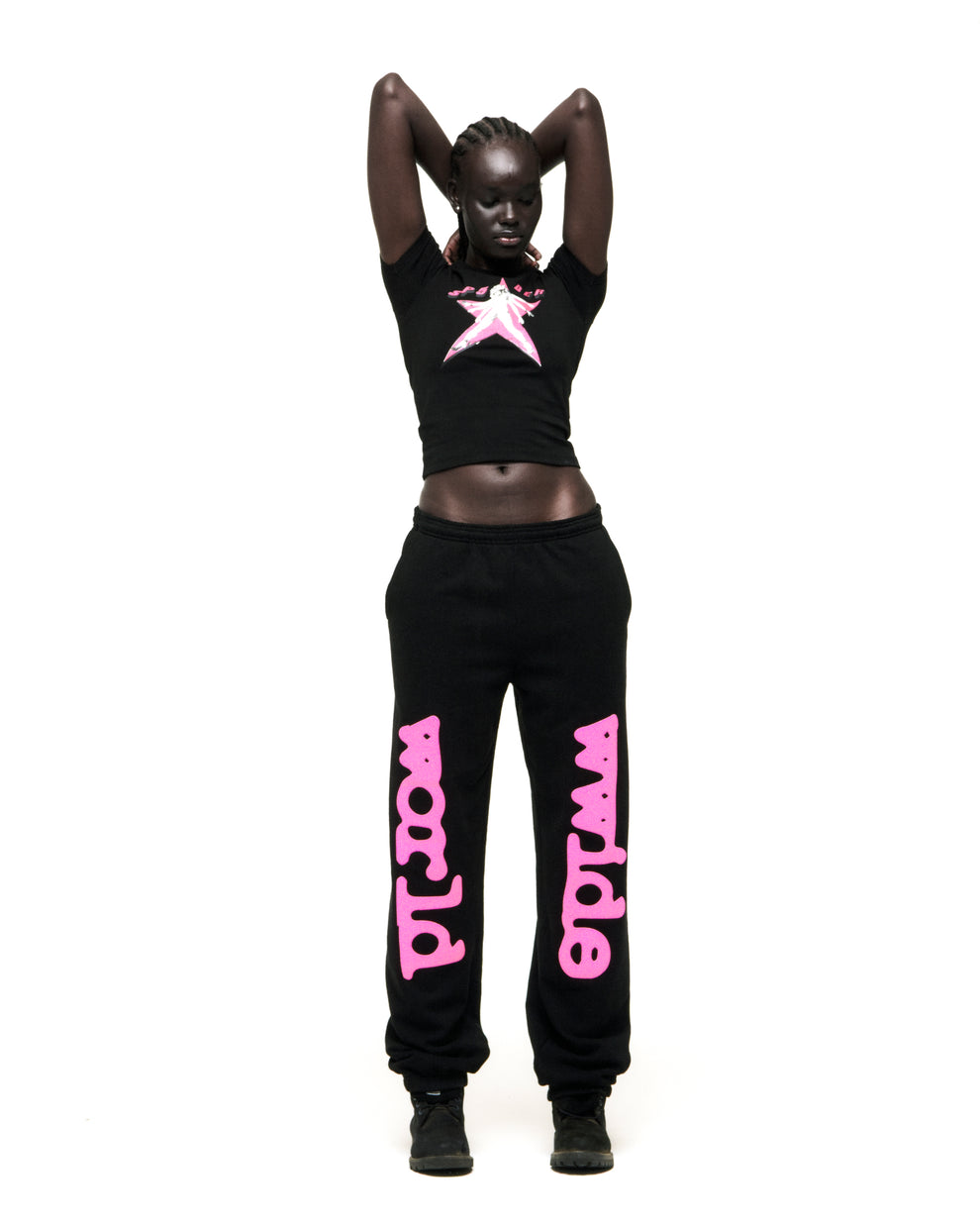 Black cropped tee with pink star graphic, paired with black sweatpants with pink "world wide" text.