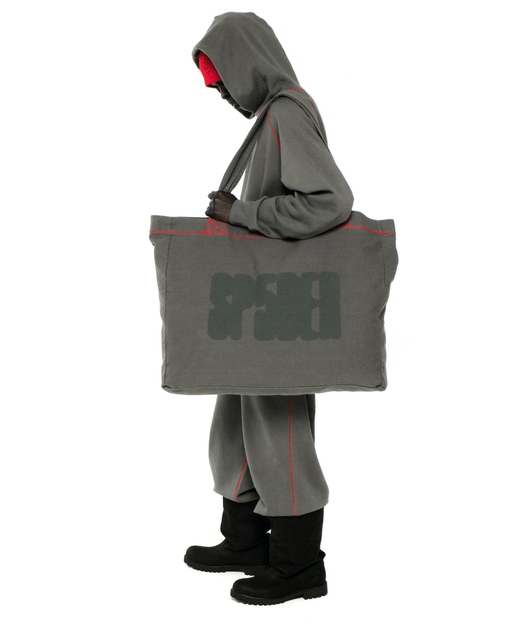 Gray 8oz brushed twill CONTRAST TOTE with SP5DER logo and red contrast stitching, carried by a person.