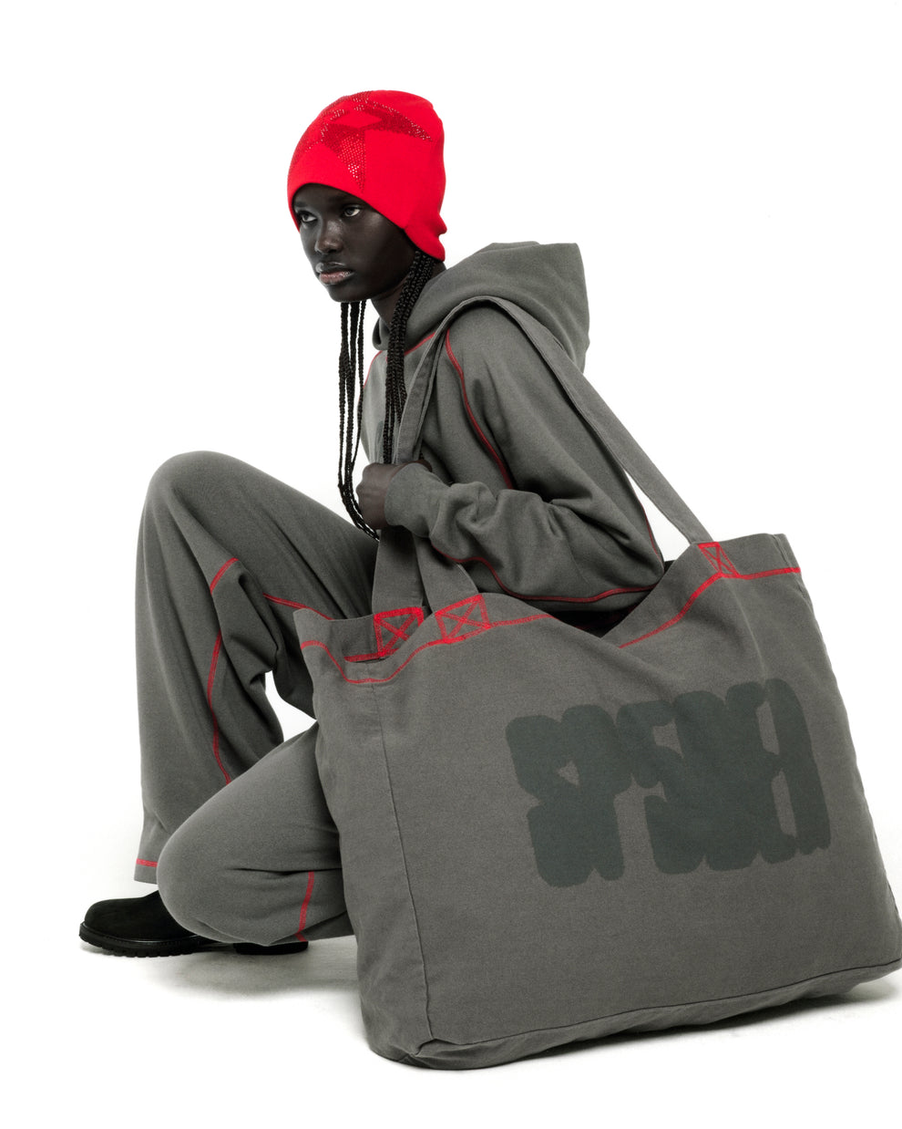 Gray brushed twill CONTRAST TOTE with SP5DER logo and red contrast stitching, held by a model.