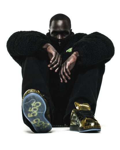 SP5DER x ADIDAS SUPERSTAR in glossy cracked gold patent leather with a spider charm and translucent sole.