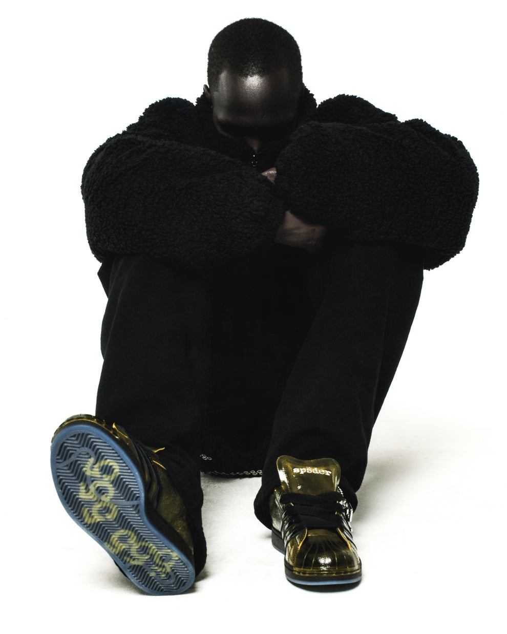 SP5DER x ADIDAS SUPERSTAR sneakers with glossy cracked patent leather in gold, translucent soles, and spider charm.