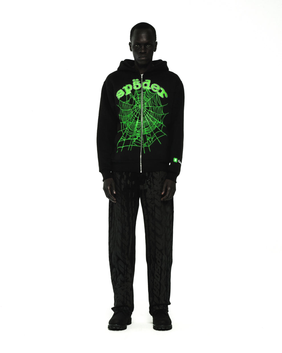 Black cotton fleece zip hoodie with green rhinestone phantom web and "Sp5der" logo.