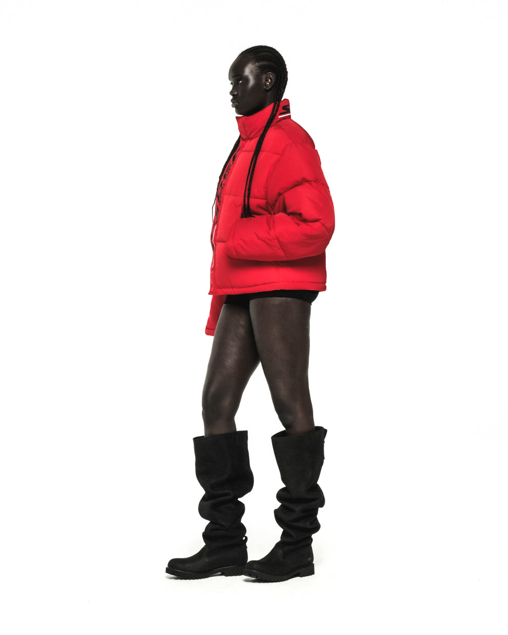 Red poly-fill TRACKHAWK puffer jacket with reflective text, side pockets, and internal drawstring hem.