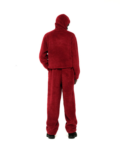 Back view of a person wearing a red teddy sherpa fleece zip-up jacket with a hood and matching pants.