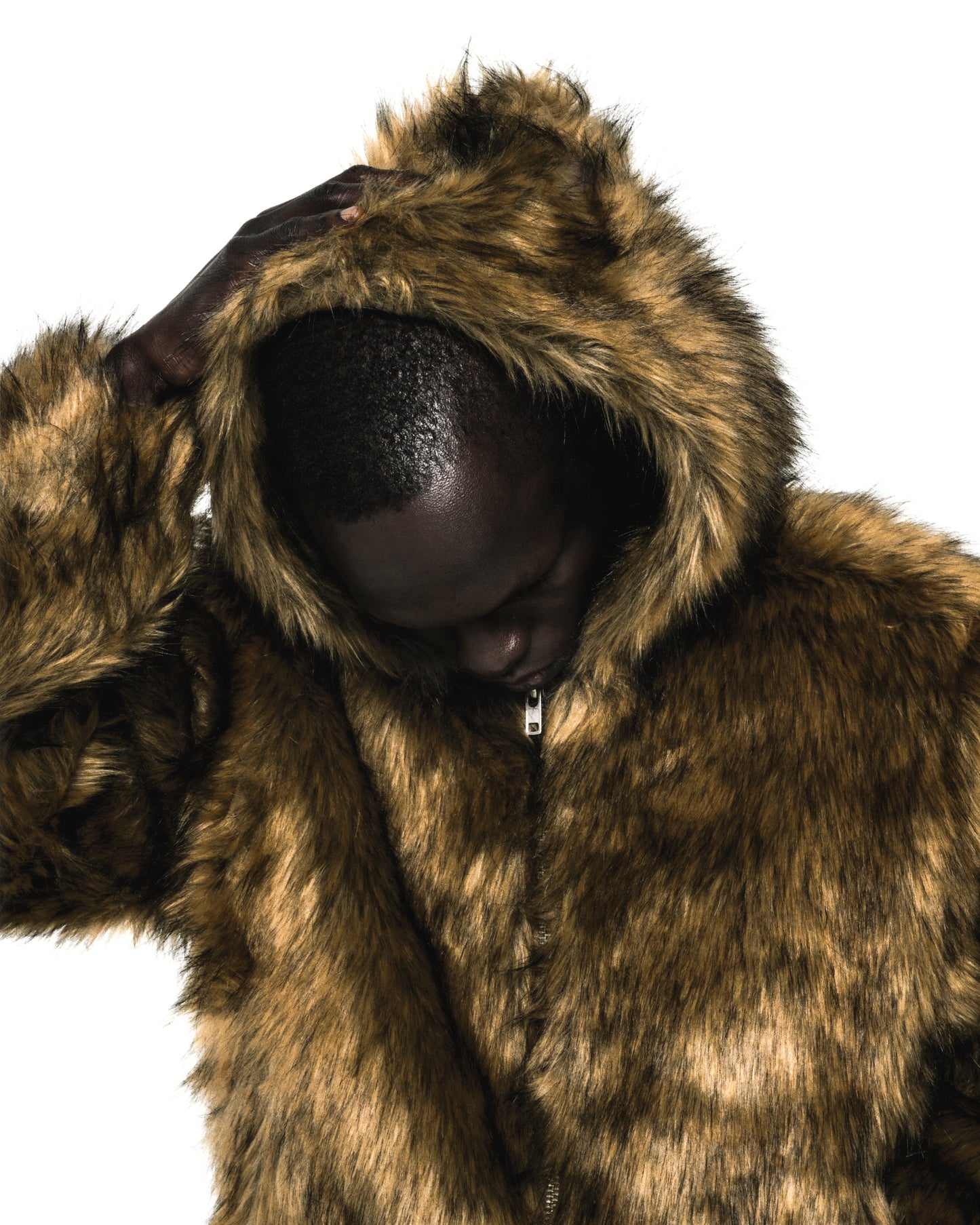Man in a brown faux fur hooded jacket with a zip closure.