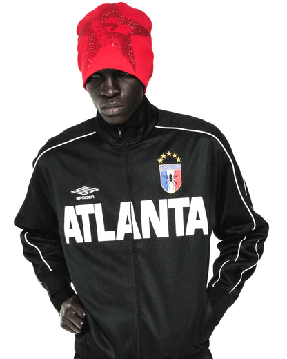 Red acrylic skully with rhinestone 5-star design worn by a model in a black track jacket.