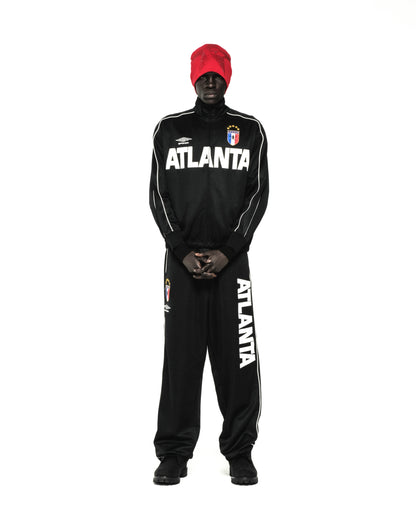 Black ATLANTA TRACK JACKET with white lettering, SP5DER crests, and contrasting piping, worn by a person.