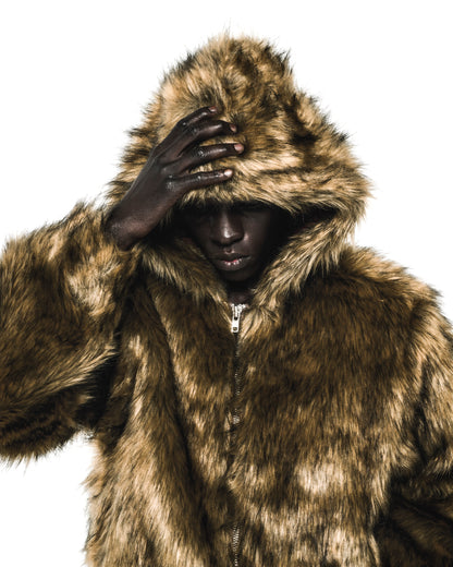 Dark-skinned model in a brown faux fur hooded jacket with a visible zipper.