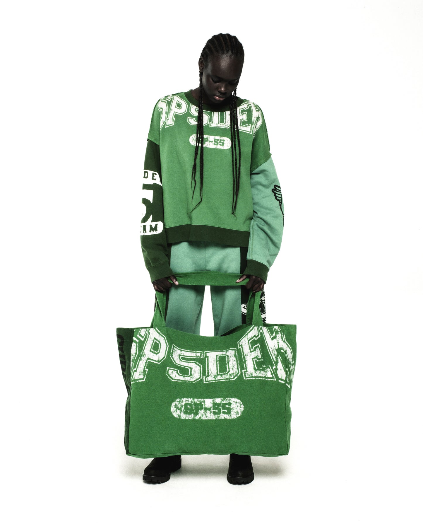 Model holding a large green SUPERFIVE TOTE with white SP5DER graphic, made from 8oz brushed twill.