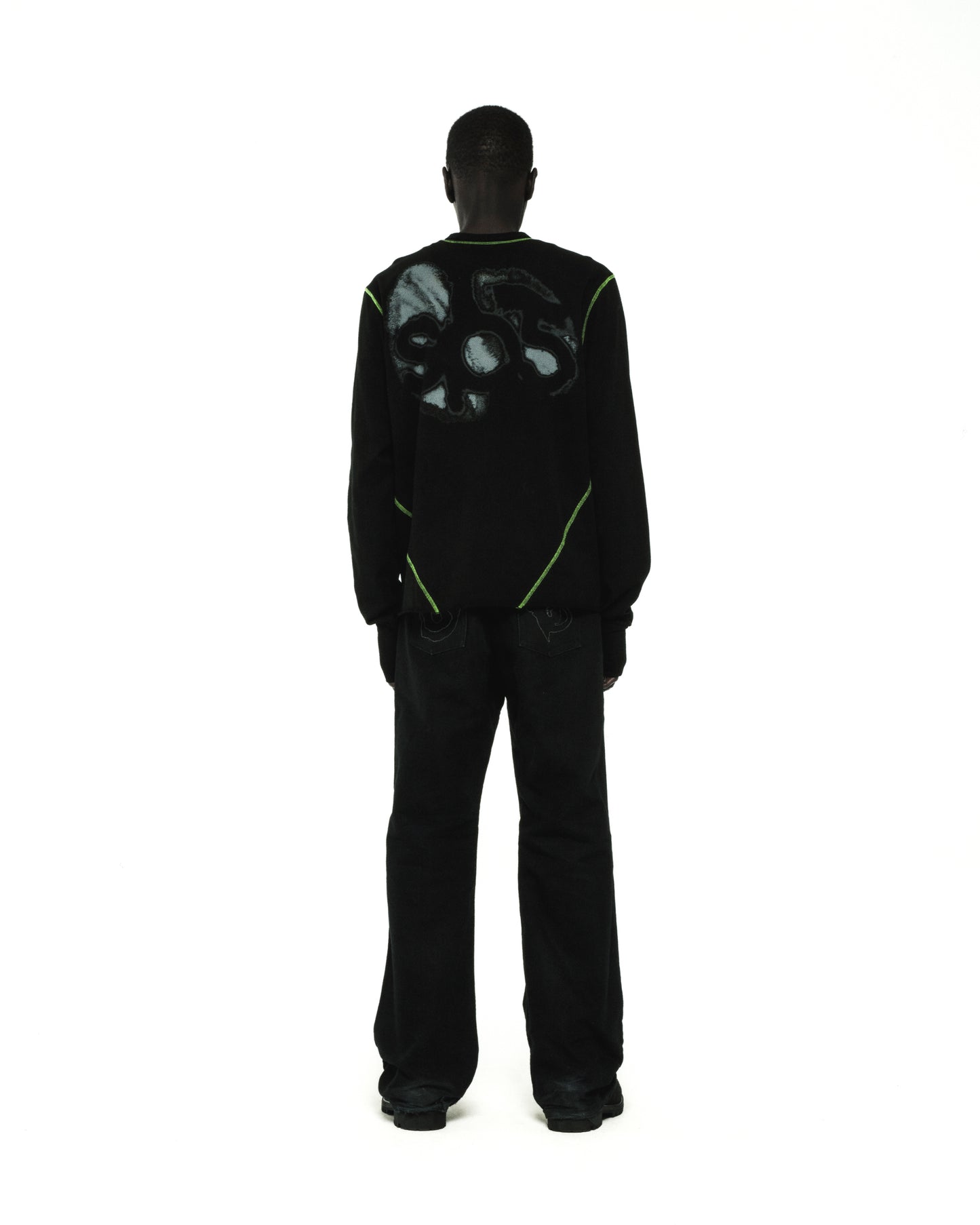 Black cotton long sleeve tee with green contrast stitching and graphic print on back.