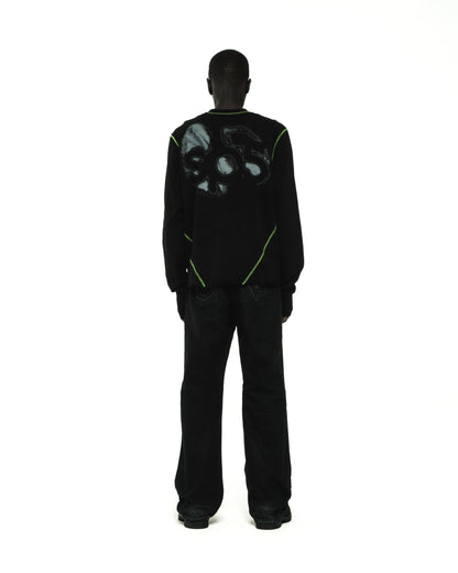 Black cotton long sleeve tee with green contrast stitching and graphic print on back.