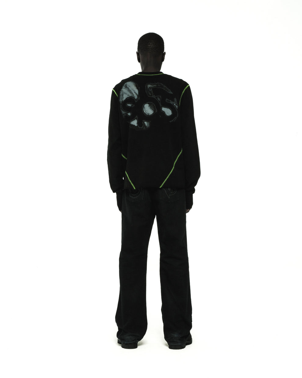 Black cotton long sleeve tee with green contrast stitching and graphic print on back.