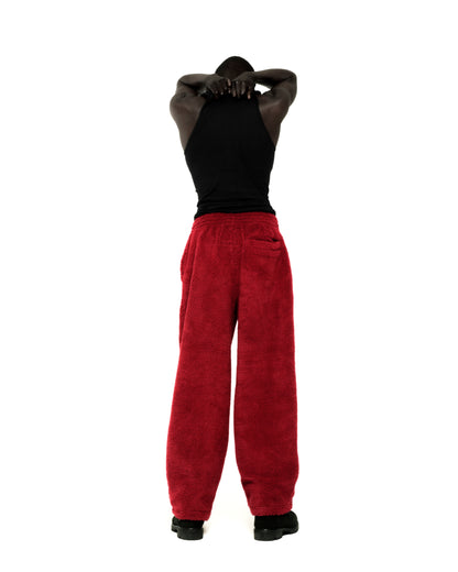 Red teddy fleece pants with elasticized waistband and straight leg fit, worn by a person from behind.