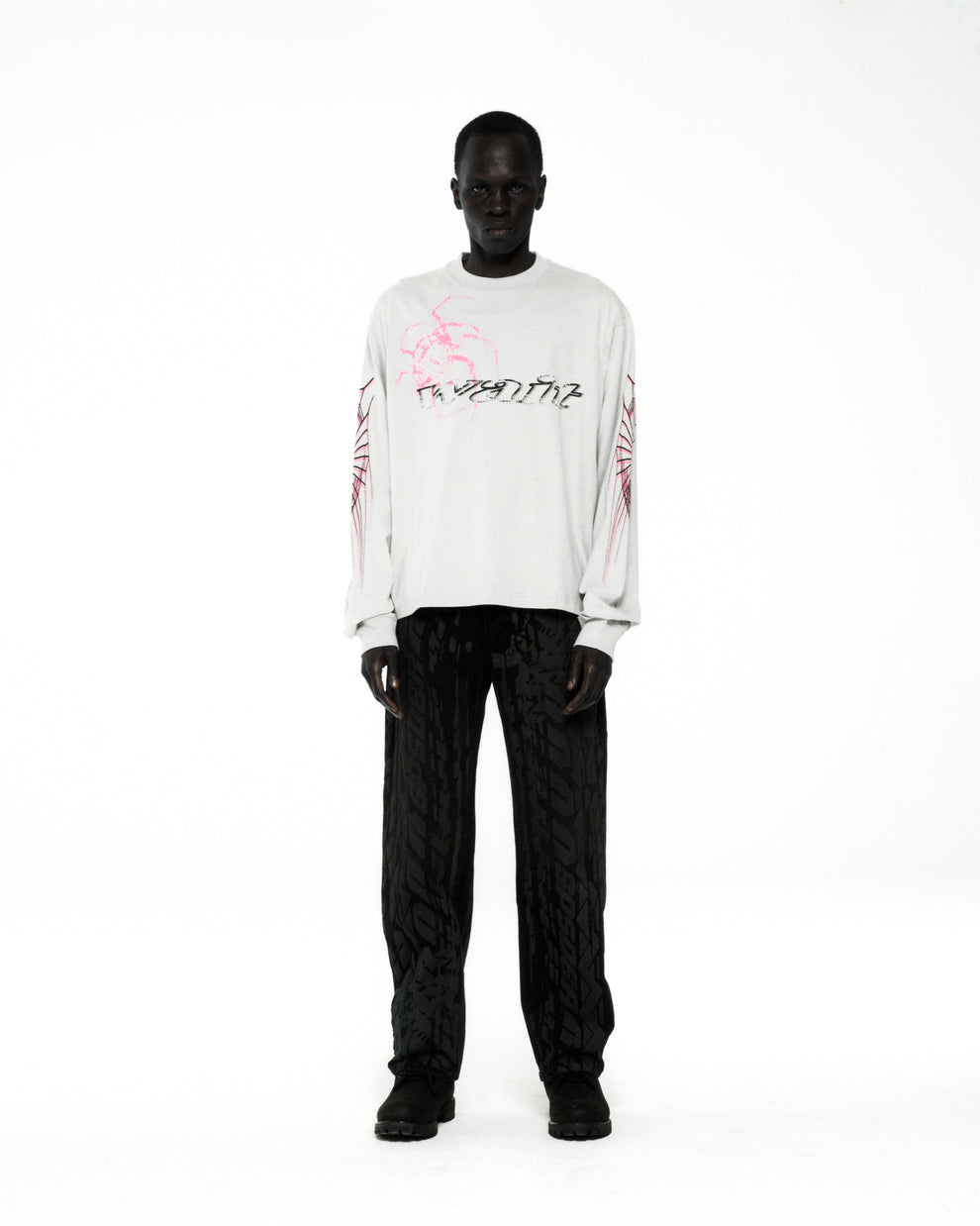 White 100% cotton WAIT LONGSLEEVE tee with pink and black graphic print on front and sleeves.