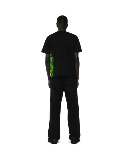 Black cotton tee with neon green heavy web graphic and star print on the side, worn by a man from behind.
