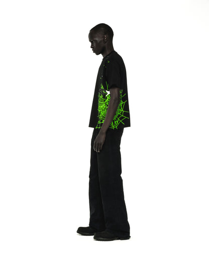 Black cotton HEAVY WEB TEE with a vibrant green spider web and star print, worn by a male model.