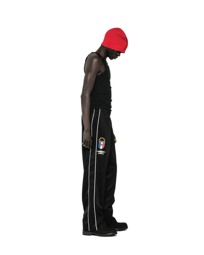 Black Atlanta Track Pant with white side piping, SP5DER crest logo, and wide-leg silhouette.