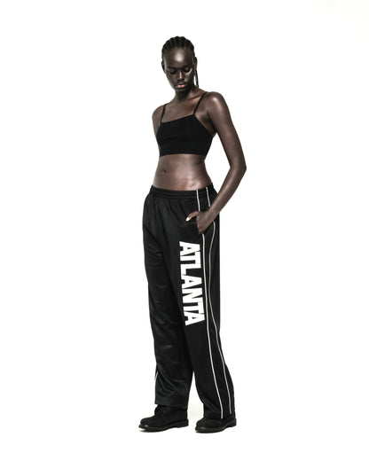 Black polyester Atlanta Track Pant with bold vertical "ATLANTA" graphic and white contrast piping.