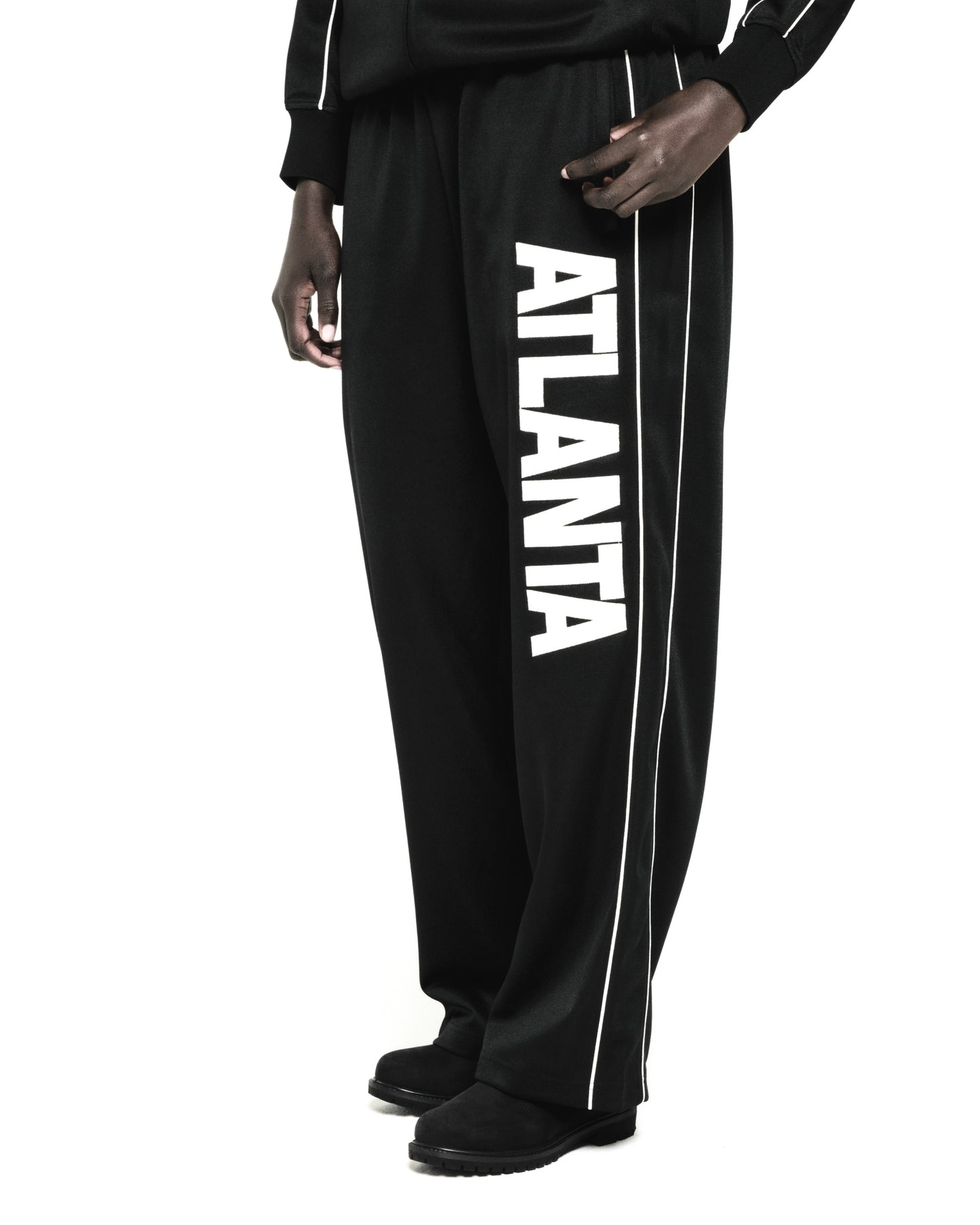 Black polyester Atlanta Track Pant with bold vertical "ATLANTA" graphic and white contrast piping.