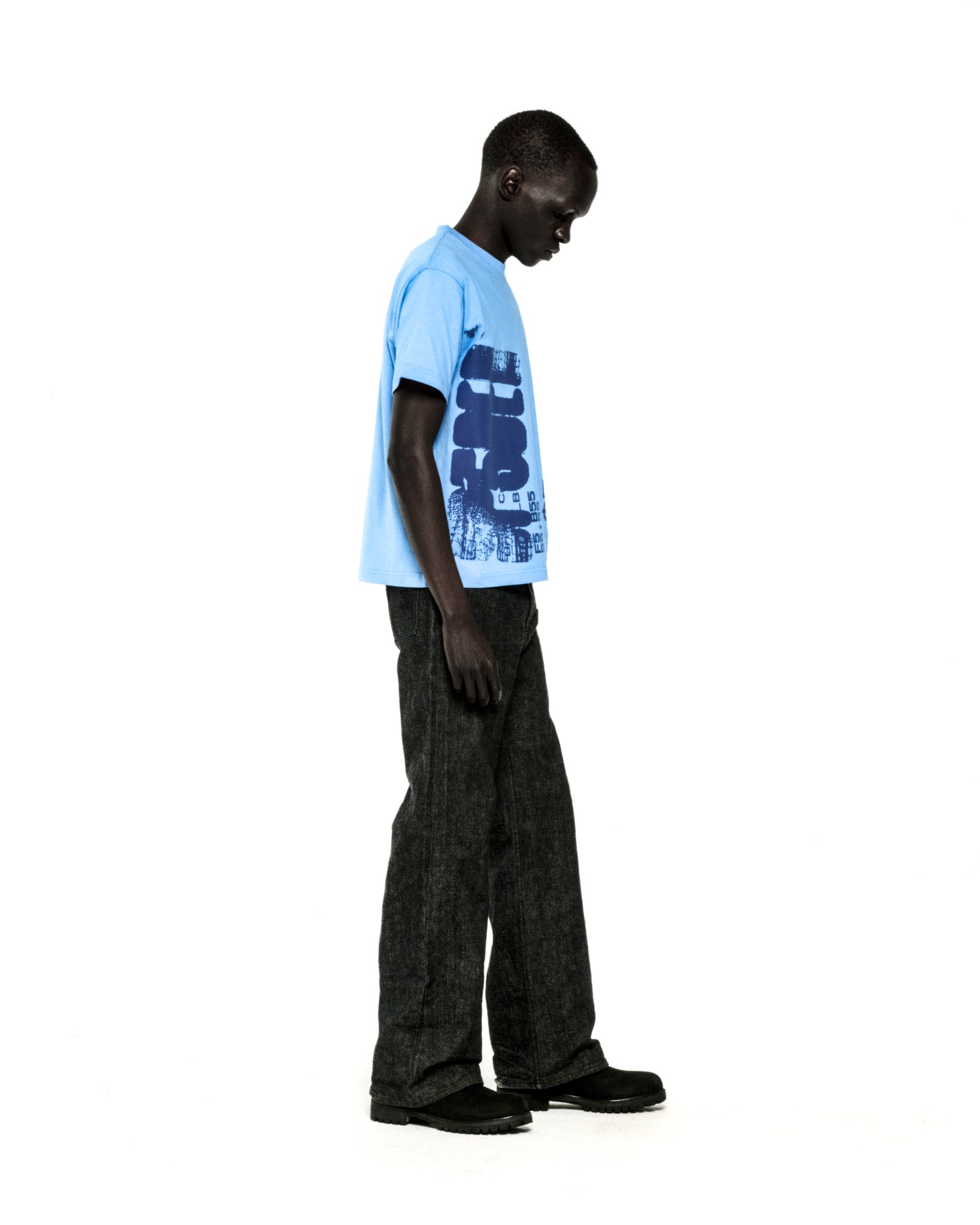 Man in a light blue 100% cotton COMMERCE TEE with a dark blue graphic print, paired with dark jeans.