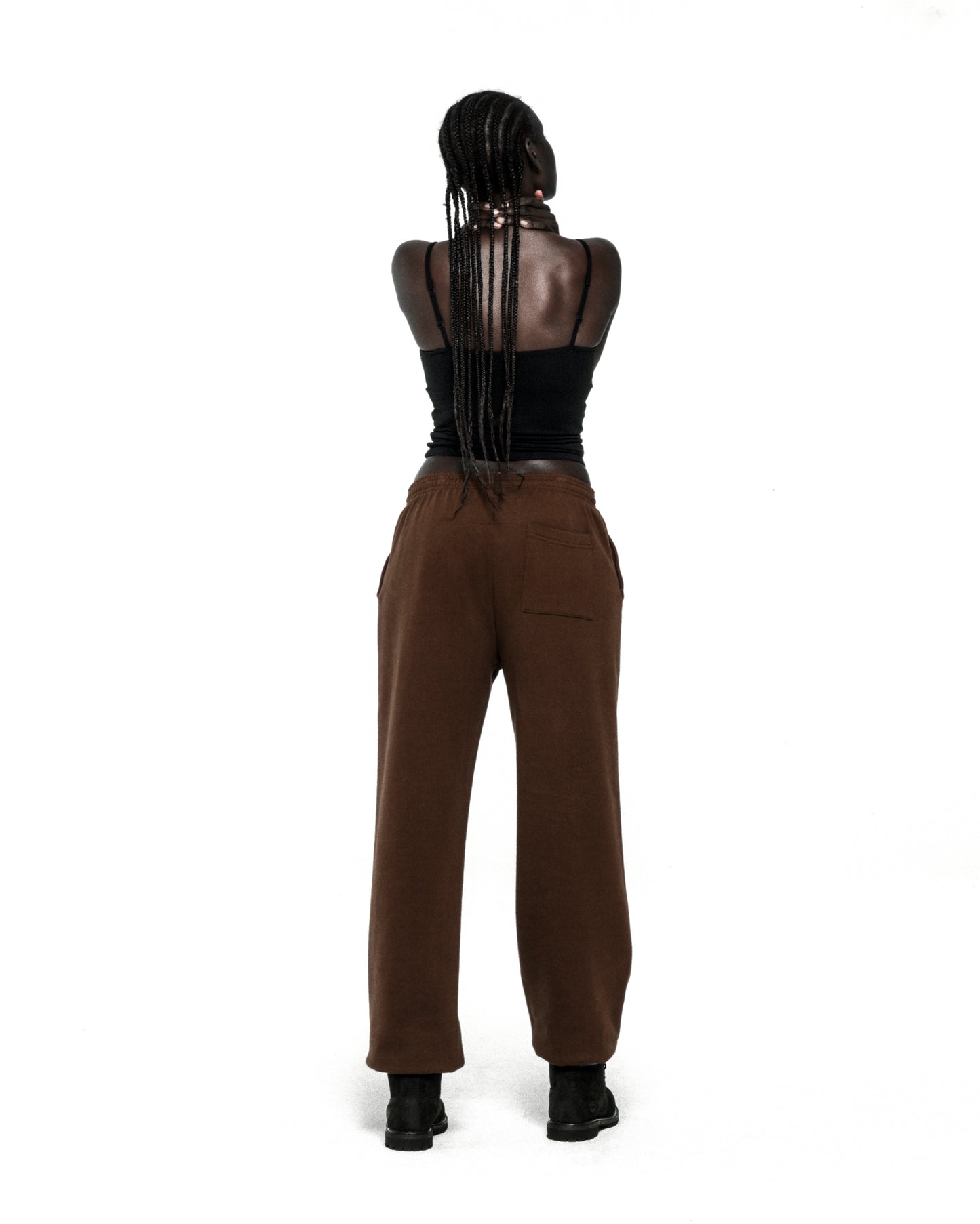 Brown 13oz cotton fleece sweatpants with elasticized waistband and cuffs, worn by a person from behind.