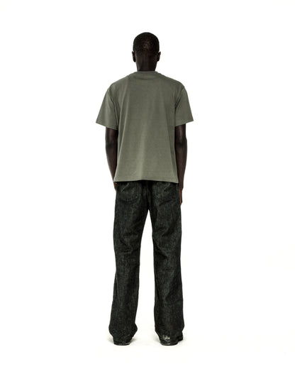 Man in standard fit, olive green cotton COMMERCE TEE and dark wash jeans, back view.