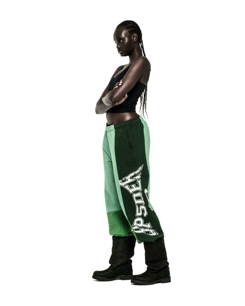 SUPERFIVE SWEATPANT: Dark-skinned model in contrast panelled green 100% cotton fleece sweatpants with graphic print.