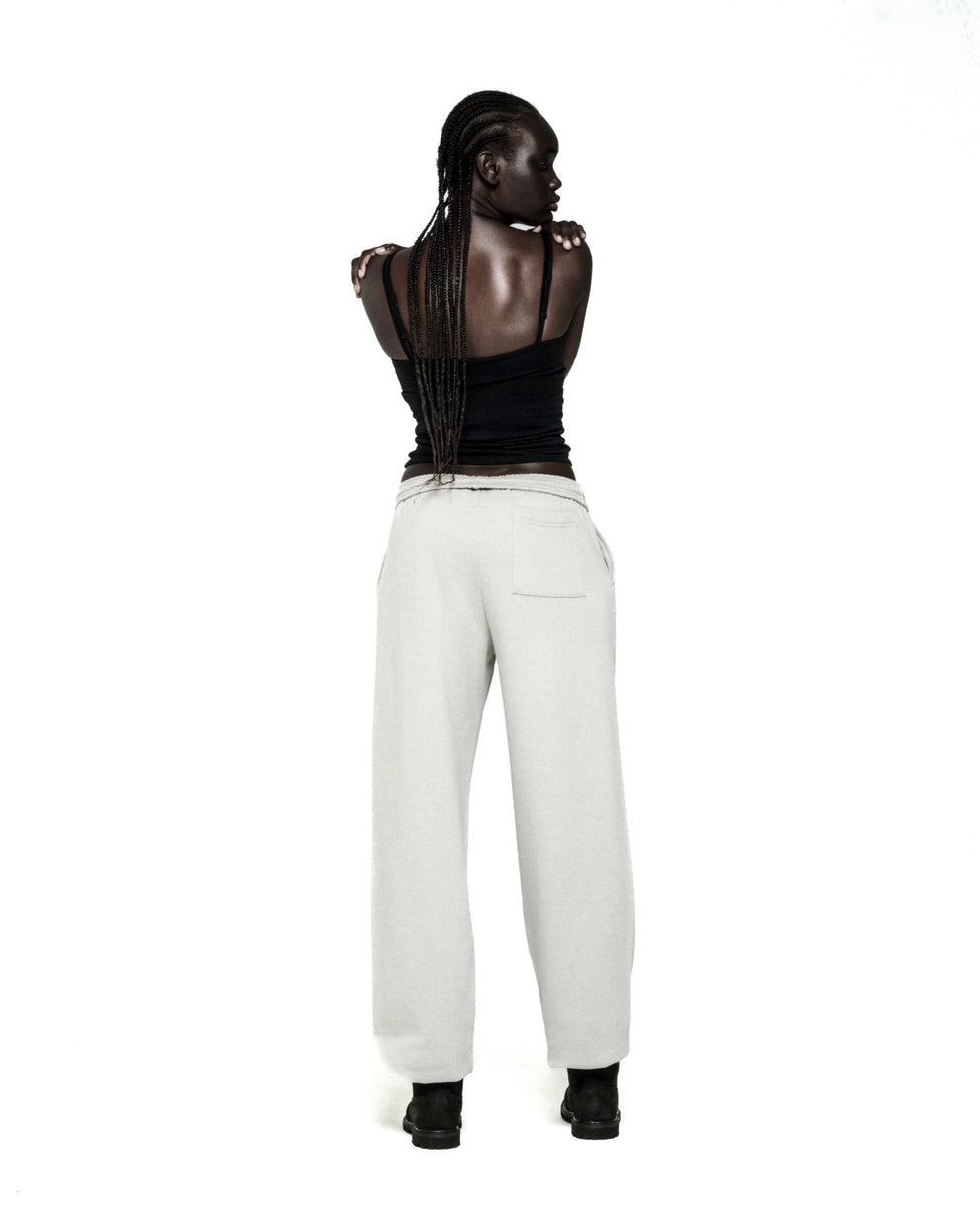 Light grey cotton fleece sweatpants with elasticized waistband and cuffs, seen from behind.