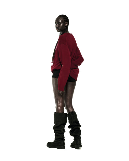Red knit sweater with graphic print, ribbed collar, hem, and cuffs, worn by a model.