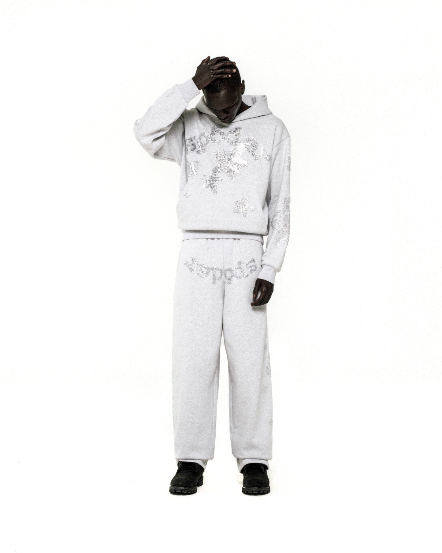 Light grey rhinestone embellished 'SP5DER' hoodie and sweatpants set on a model.