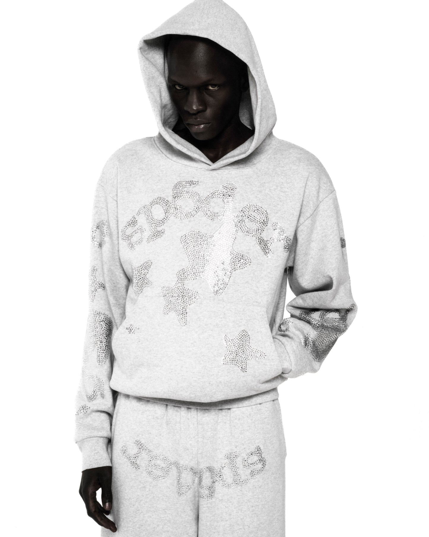 Light grey RHINESTONE BELUGA HOODIE with 'SP5DER' and star design, kangaroo pocket, and matching sweatpants.