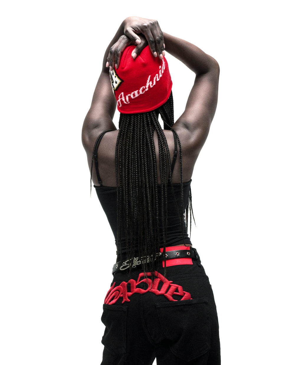 Red acrylic skully with "Arachnid" embroidery and varsity graphic, worn by a person with braids.