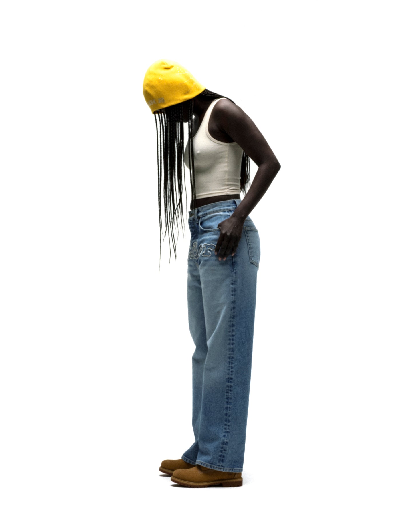 Yellow rhinestone silk skully on a model, featuring a skull design, paired with jeans and a white top.