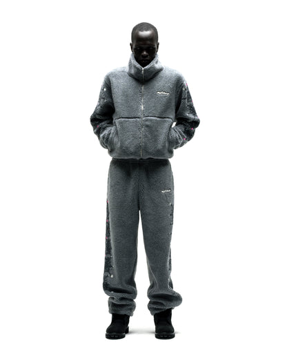 Gray sherpa fleece zip-up jacket and pants with web print, rhinestones, and logo patch.