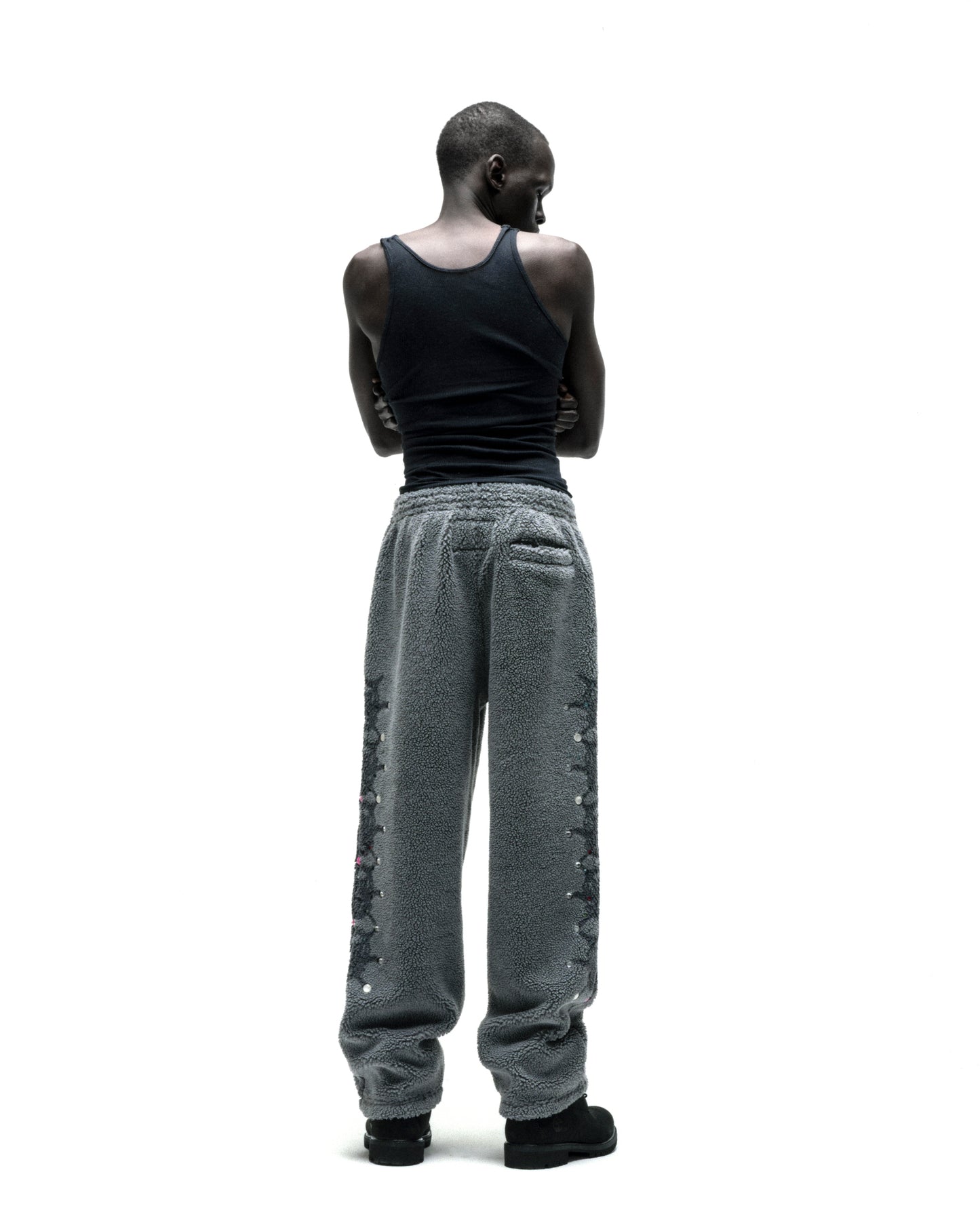 Gray sherpa fleece pants with web print, rhinestone embellishments, and a rubberized logo patch.