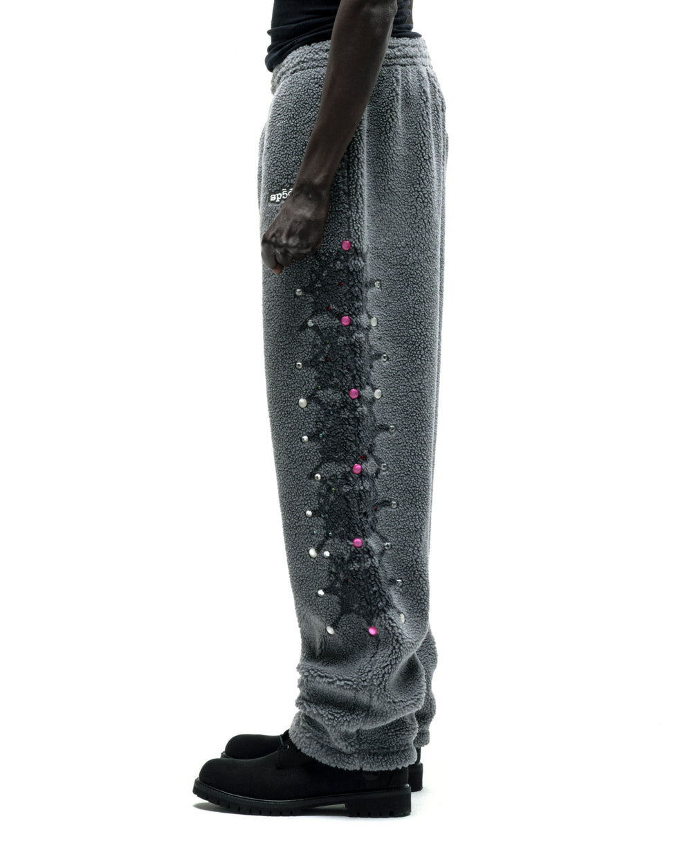Gray sherpa fleece pants with web print, rhinestones, and rubberized logo patch on leg.
