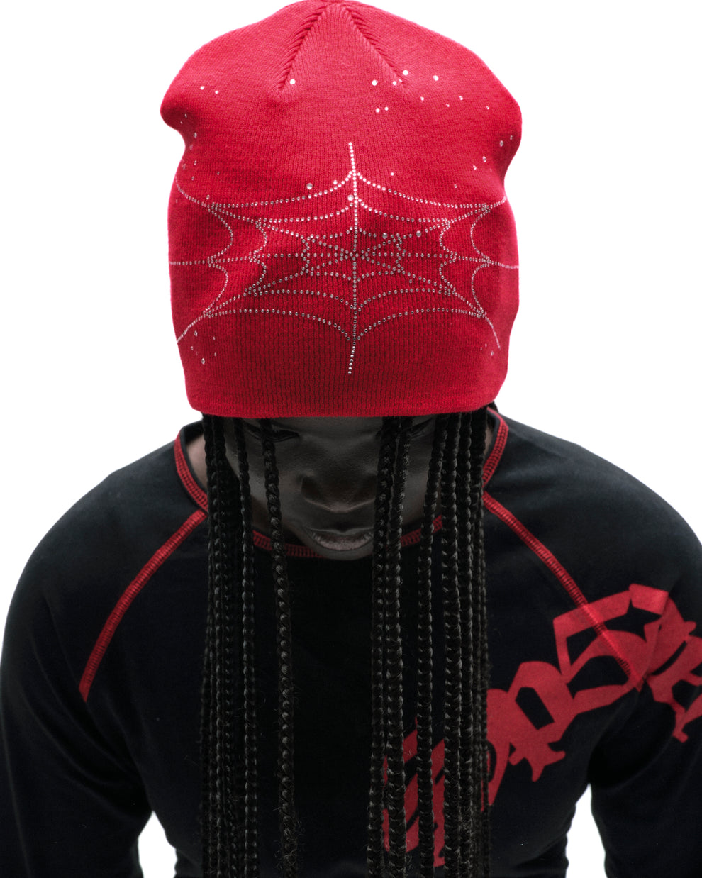 Red acrylic rhinestone skullcap with a spiderweb design, worn by a person with braids.
