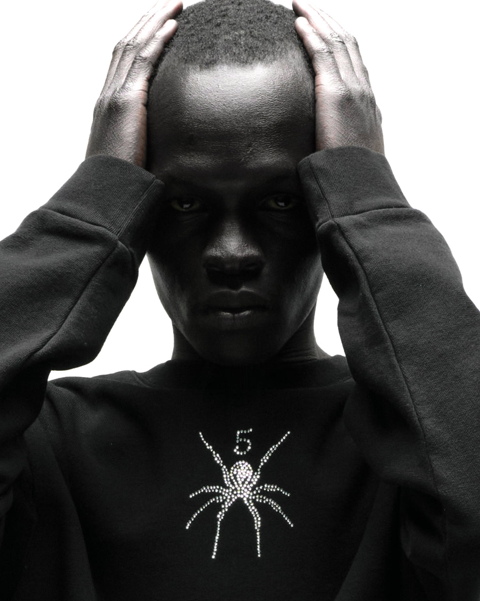 Black 100% cotton RHINESTONE TM CREWNECK with rhinestone spider graphic, worn by a person.