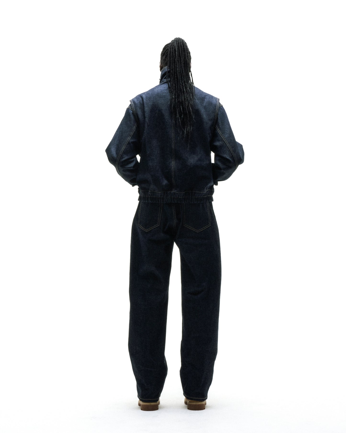 Dark wash denim jacket and straight leg jeans on a person with braided hair, viewed from behind.